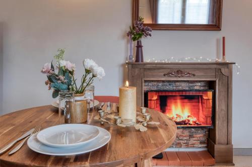 a table with a candle and a fireplace at Cottage Au Coin du Feu in Rambouillet