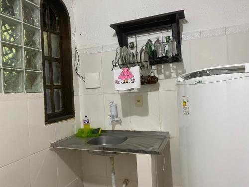 uma pequena cozinha com um lavatório e um frigorífico em Rio natureza apart 104 no Rio de Janeiro