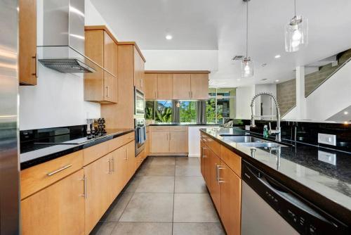 a large kitchen with wooden cabinets and black appliances at Tempe Lofts in Tempe