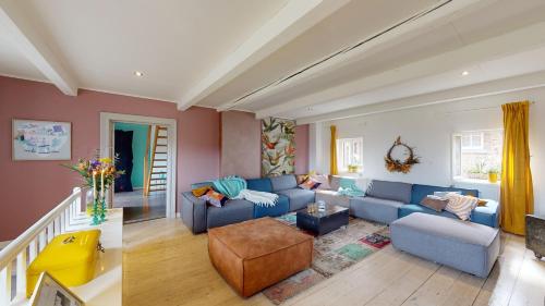 a living room with a blue couch and a chair at SintPieter17 Lo-Ghis vakantiewoning in Voeren