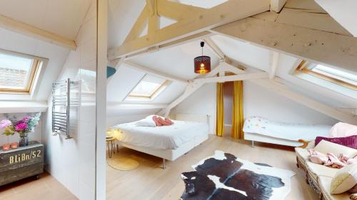 um quarto no sótão com uma cama e um sofá em SintPieter17 Lo-Ghis vakantiewoning em Voeren
