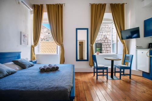 a bedroom with a bed and a table and chairs at LE MURA OLD TOWN APARTMENT by DuHomes in Dubrovnik