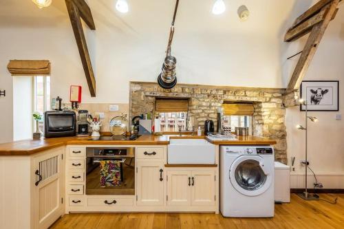 una cocina con lavadora y secadora. en The Stocks Barn en Wellingore