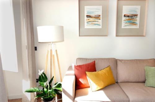 uma sala de estar com um sofá com almofadas coloridas em El Sireno de Vigo, céntrico, amplio y acogedor em Vigo