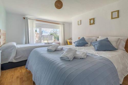 1 dormitorio con 1 cama grande con almohadas azules en Vila Cristina, en Valdemorillo