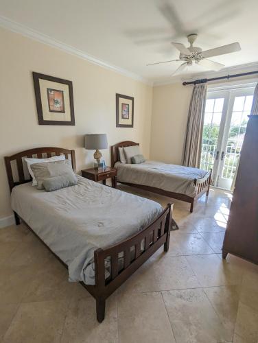 a bedroom with two beds and a ceiling fan at Villa Renaissance Grace Bay in The Bight Settlements