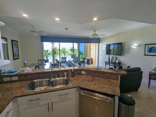 a kitchen with a sink and a living room at Villa Renaissance Grace Bay in The Bight Settlements