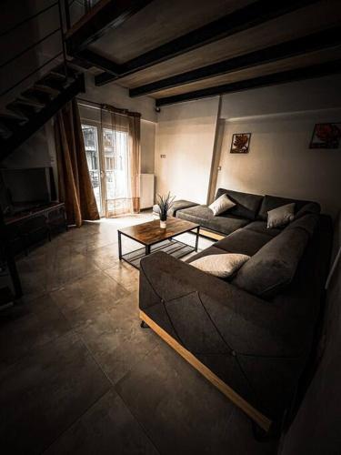 a living room with a couch and a table at Escala Double Loft 1 & Parking in the City Center in Volos