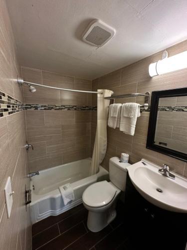 a bathroom with a white toilet and a sink at Bestway Inn in Muncie