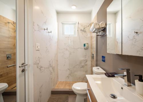 a bathroom with a toilet and a sink and a shower at Rosalina Ocean Park in San Juan