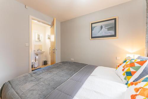 1 dormitorio con 1 cama grande y baño en CITY CENTRE FLAT With Free Parking, Fast Wifi, Smart TV And 2 Bathrooms, 7min walk from Train Station!, en Coventry