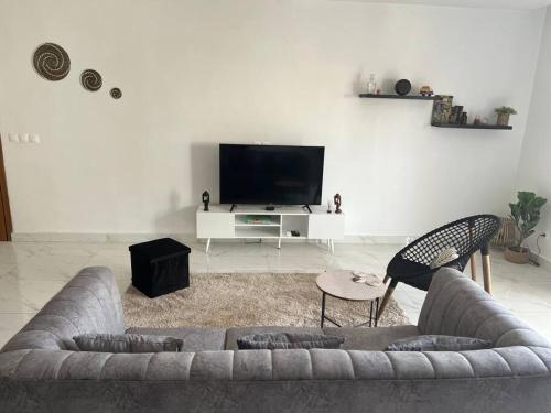 a living room with a couch and a tv at 2br modern apartment in Almadies in Dakar