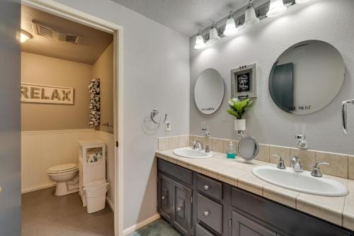 baño con 2 lavabos, aseo y espejos en Casa Del Moro Klamath Falls Apt Pool and Hot Tub!, en Klamath Falls