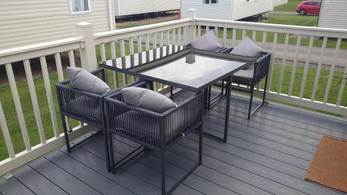 a patio with two chairs and a table on a deck at Your Holidays in Scotland. in Eyemouth