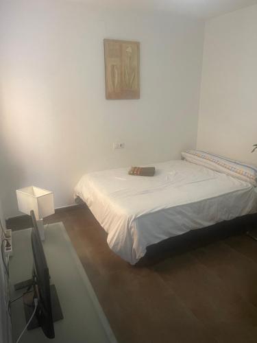 a bedroom with a bed and a picture on the wall at Apartamento Gloria Patricia in Alcantarilla