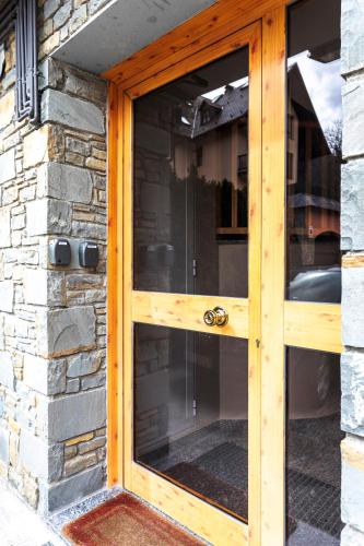 a wooden door of a house with a stone wall at Apartamento en Vielha in Vielha