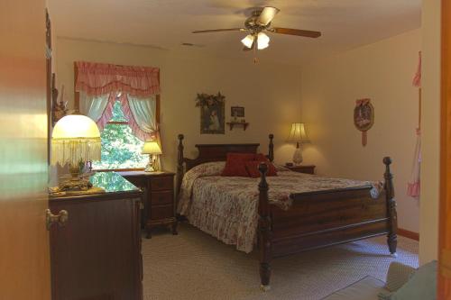 um quarto com uma cama, um candeeiro e uma janela em Secluded Chalet - Pet Friendly em Columbus