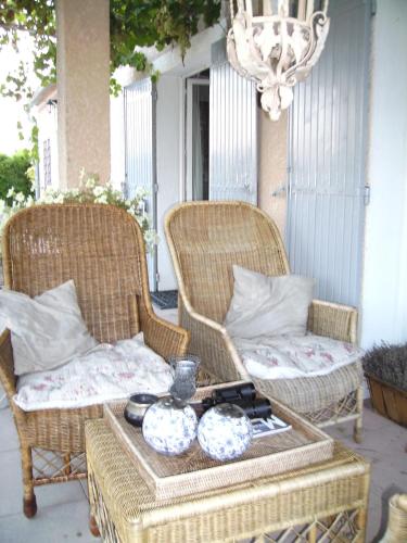 two wicker chairs and a table on a porch at "Le Vent d'Étoile" B&B and Guesthouses in Mormoiron