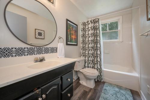 ein Badezimmer mit einem Waschbecken, einem WC und einem Spiegel in der Unterkunft Peaceful Country House With Fireplace And Firepit in Mill Spring