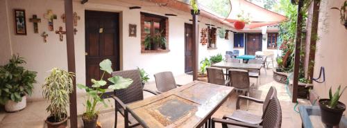 an outdoor patio with a table and chairs and plants at Hostal Tía Mema in Santa Ana