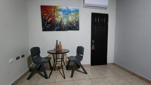 a dining room with a table and chairs and a painting at Hostal Tía Mema in Santa Ana
