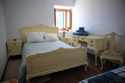 a bedroom with a bed and two dressers and a desk at Primor Serra AL in Covilhã