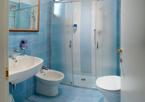 a bathroom with a toilet and a sink and a shower at Hotel Gioiosa in Cesenatico