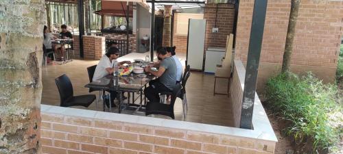 two men sitting at a table on a patio at Cosmic Connect Trails Kabini in Antarasante
