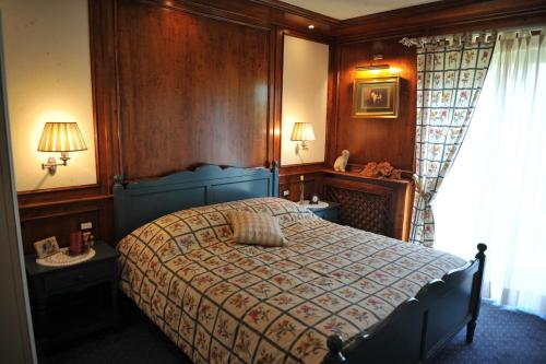 a bedroom with a bed and two tables and a window at Bonavia B&B in Sistiana