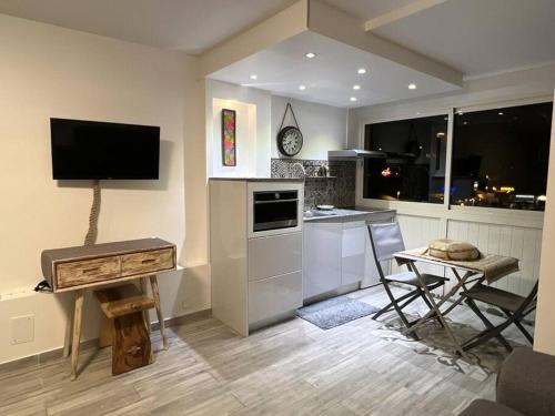 una cucina con TV, tavolo e sedie di C l e a n & N e w - cosy flat marina PAP Gosier a Pointe-à-Pitre