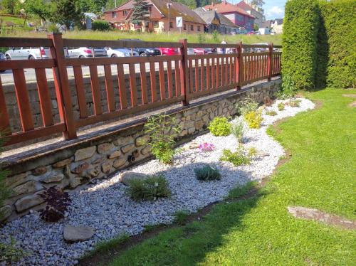 a garden with a wooden fence and some plants at Hotel Terasa in Vimperk