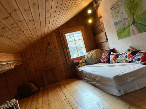 - un canapé dans une chambre dotée d'un plafond en bois dans l'établissement Chalet La Paz with Hotpot and Sauna, à Törbel