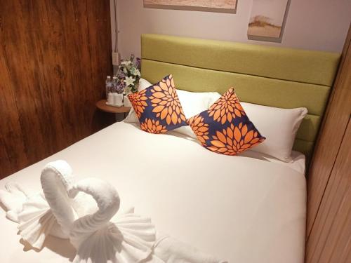 a bed with two swans on it with pillows at Icon Hotel Hatyai in Hat Yai