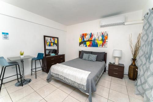 a bedroom with a bed and a desk and a table at Green Studio 1 - just 7 min drive to the beach in Rincon