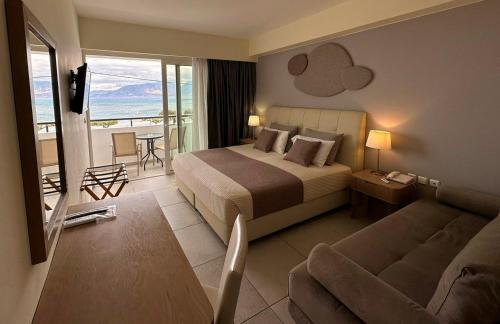 アギオス・ニコラオスにあるFaedra Beachのベッドとソファ付きのホテルルーム
