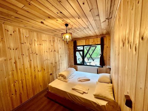 a bedroom with a bed in a wooden room at TUVA VİLLA Bungalov in Çamlıhemşin