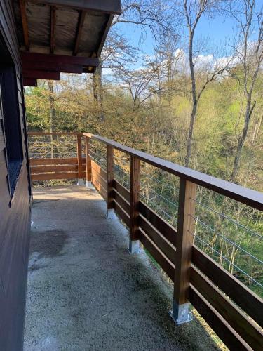 a porch of a house with a wooden fence at Gîtes Douillets : Chalet sur Pilotis in Houyet