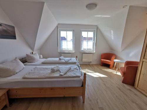 a bedroom with two beds in a attic at Ferienhaus Baltrumkieker Mitte in Neßmersiel