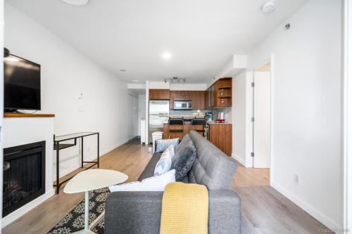 a living room with a couch and a fireplace at Modern DT Vancouver 1BD Condo in Vancouver