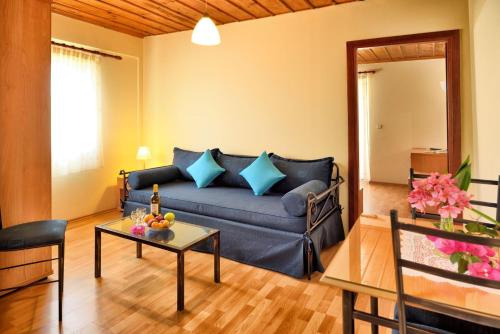 a living room with a blue couch and a table at Studio Nikiti Beach in Nikiti