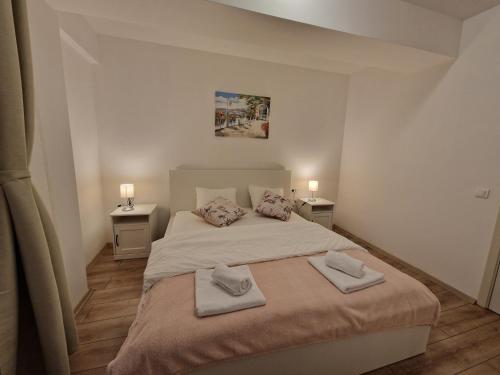 1 dormitorio con 1 cama con 2 toallas en Sky Airport Residence, en Otopeni