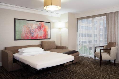 Pokój hotelowy z łóżkiem i krzesłem w obiekcie Houston Marriott Sugar Land w mieście Sugar Land