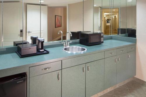 W łazience znajduje się umywalka i lustro. w obiekcie Houston Marriott Sugar Land w mieście Sugar Land