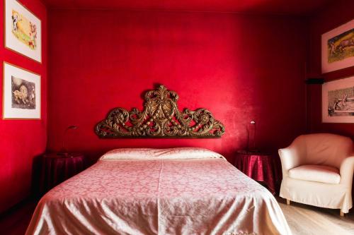 a red bedroom with a bed and a chair at Locanda Da Lino in Pieve di Soligo