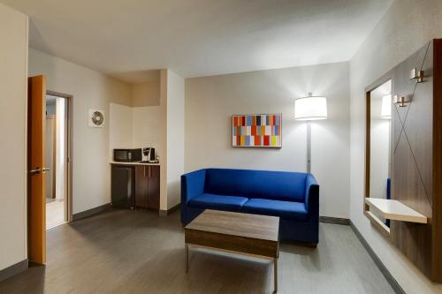 a living room with a blue couch and a table at Holiday Inn Express I-95 Capitol Beltway - Largo by IHG in Largo