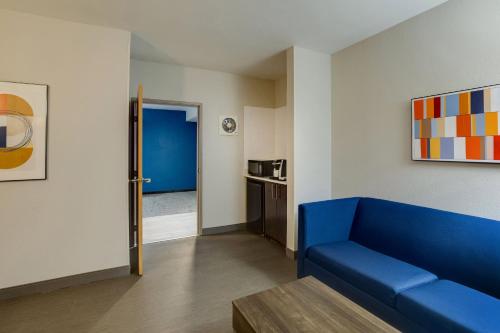 a living room with a blue couch and a kitchen at Holiday Inn Express I-95 Capitol Beltway - Largo by IHG in Largo