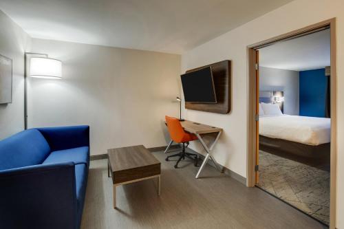 a hotel room with a bed and a desk and a chair at Holiday Inn Express I-95 Capitol Beltway - Largo by IHG in Largo