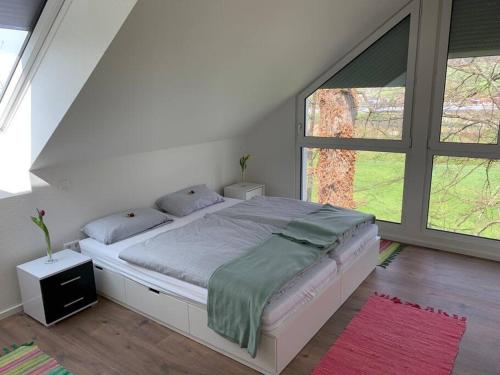 een bed in een slaapkamer met een groot raam bij Wohnung am Fuße des Schwarzwalds in Oberkirch