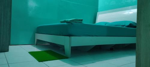 a bed in a room with a blue wall at faTuur Inn in Male City