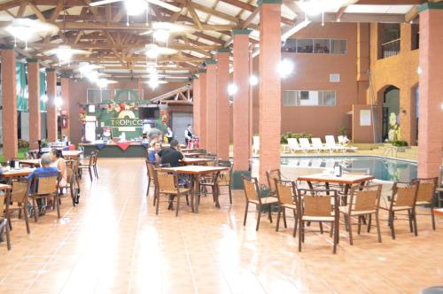 a restaurant with tables and chairs and a swimming pool at Hotel Tropico Inn in San Miguel